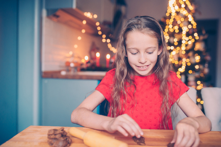 Adorable little girl baking Christmas gingerbread cookiesの写真素材