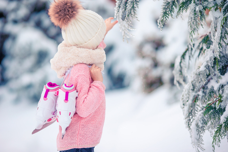 Cute little kid girl is going skate outdoors.の写真素材