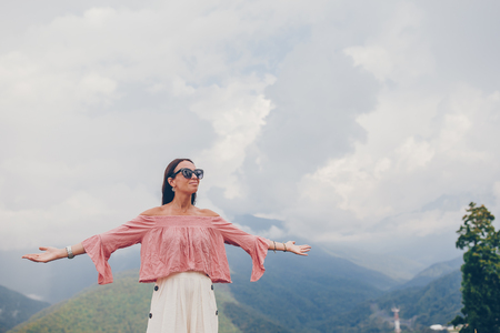 Beautiful happy young woman in mountains in the background of fogの写真素材
