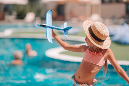 Beautiful little girl having fun near an outdoor poolの写真素材