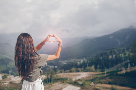 Beautiful happy young woman in mountains in the background of fogの写真素材