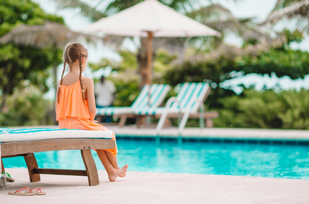 Little happy adorable girl in outdoor swimming poolの写真素材