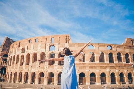 Back view of young woman in front of Colosseum in Rome, Italyの写真素材