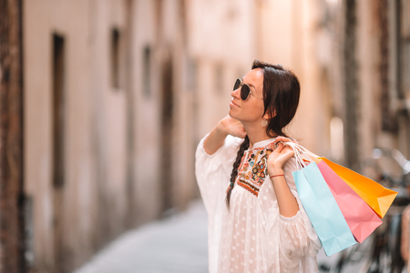 Young girl with shopping bags on narrow street in Europe.の写真素材