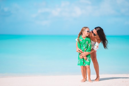Beautiful mother and daughter at Caribbean beach enjoying summer vacation.の写真素材