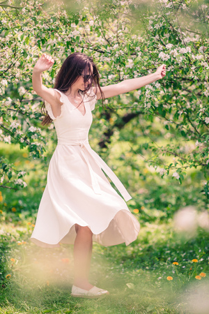 Beautiful woman enjoying smell in spring cherry gardenの写真素材