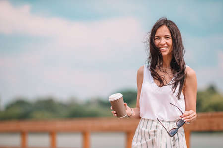 Young beautiful woman drinking coffee in the park.の写真素材