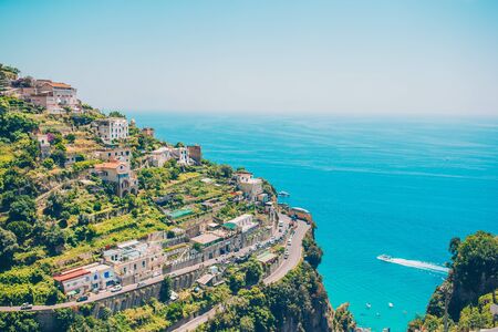 Beautiful cozy bay with small houses on the hill and clear turquoise water in Italy on Amalfi coast