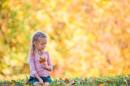 Adorable little girl at beautiful autumn day outdoorsの写真素材