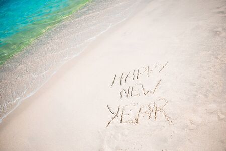 Happy New Year written in the white sandの写真素材