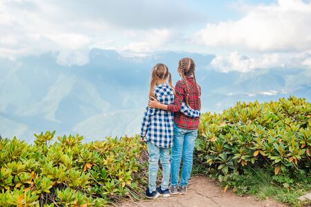 Little kids on summer vacation enjoy the view in mountainsの写真素材