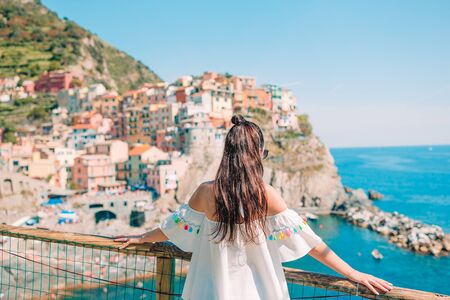 Tourist looking at scenic view of Manarola, Cinque Terre, Liguria, Italyの写真素材
