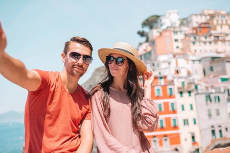 Tourists looking at scenic view of Riomaggiore, Cinque Terre, Liguria, Italyの写真素材