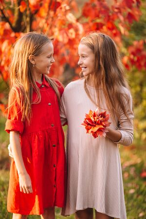 Little adorable girls outdoors at warm sunny autumn dayの写真素材