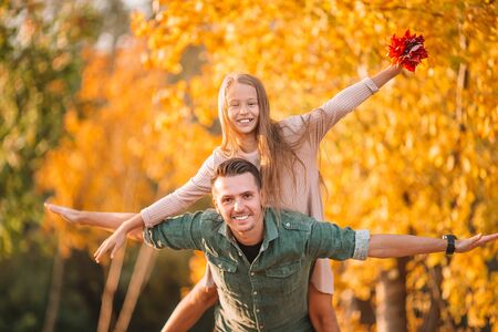 Family of dad and kid on beautiful autumn day in the parkの写真素材
