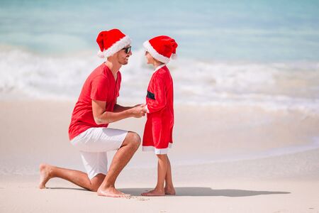 Father and daughter in Santa Hat have fun at tropical beachの写真素材
