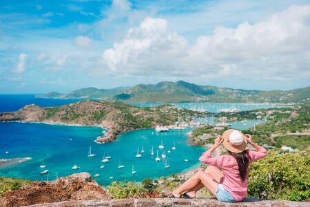 Happy woman enjoying the view of picturesque English Harbour at Antigua. View of paradise bay at tropical island in the Caribbean Seaの写真素材