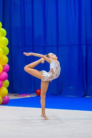 Beautiful little gymnast girl on the carpet on the competitionの写真素材