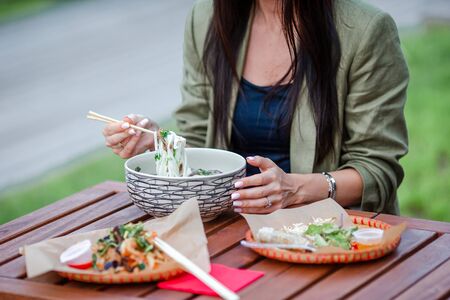 Asian rice noodles with vegetables and sause close-up on the table and tasty soup Fo Bo