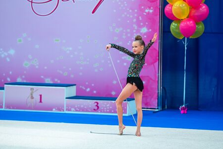 Beautiful little gymnast girl on the carpet on the competitionの写真素材