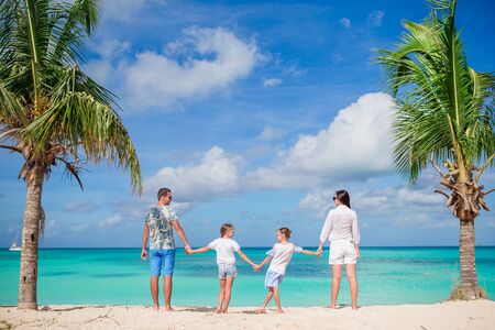 Happy beautiful family of four on the beachの写真素材
