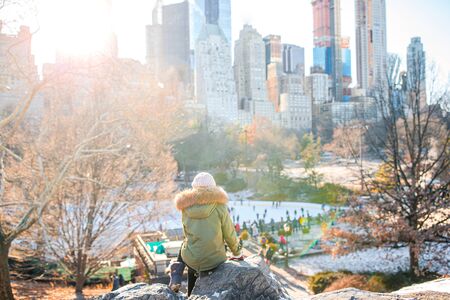 Adorable girl with view of ice-rink in Central Park on Manhattan in New York Cityの写真素材