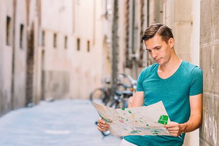 Young man with a city map in european city.の写真素材
