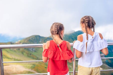 Beautiful happy little girls in mountains in the background of fogの写真素材