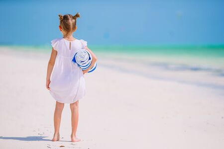 Adorable little girl on the beach. Happy girl enjoy summer vacation background the blue sky and turquoise water in the seaの写真素材