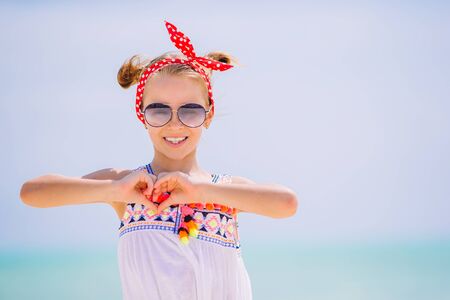 Beautiful little girl at beach having fun. Portrait of funny girl enjoy summer vacationの写真素材