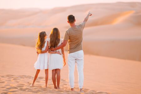 Back view of family enjoying the view of natural desert. Father shows his kids beautiful landscape of desertの写真素材