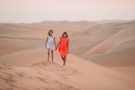 Beautiful girls at dunes in most big sand desert in the worldの写真素材