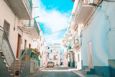 The narrow streets with stairs, white houses and flowers in beautiful village in Italy.の写真素材