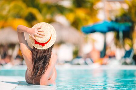 Beautiful young woman relaxing in swimming pool.の写真素材