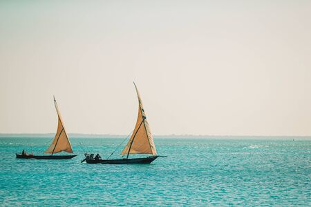 Beautiful white sandy beach with boats and clear turquoise waterの写真素材