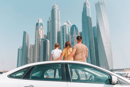 Family summer vacation. Father and kids on car vacation on background of skyscrapers in Dubaiの写真素材
