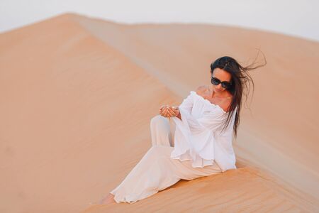 Beautiful woman in dunes in the most big desert in Emiratesの写真素材