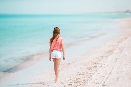 Active little girl at beach having a lot of fun in shallow waterの写真素材