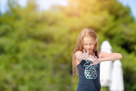 Little adorable girl in outdoor swimming pool