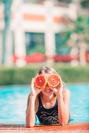 Little happy girl in outdoor swimming pool relaxingの写真素材