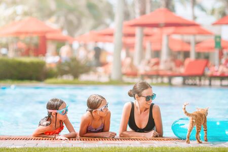 Mother and two kids enjoying summer vacation in luxury swimming poolの写真素材