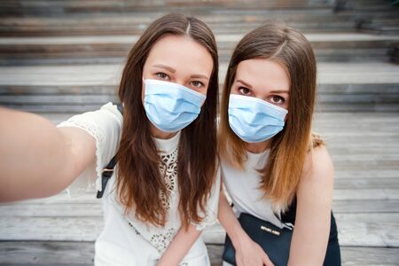 Portrait of caucasian beautiful girls making selfie outdoors. Young tourist friends traveling on holidays smiling happy.の写真素材