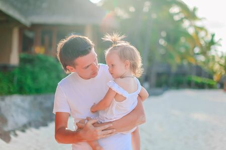 Little girl and happy dad having fun during beach vacationの写真素材