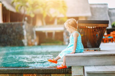 Little adorable girl splashing in outdoor poolの写真素材