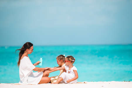 Young mother applying sun cream to daughter nose on the beach. Sun protectionの写真素材