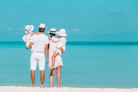 Back view of family on the tropical beachの写真素材