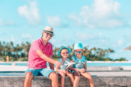 Family of dad and children on wooden jetty by the oceanの写真素材
