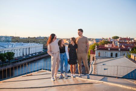 Family on rooftop enjoying with view of beautiful sunset in Sankt Petersburg in Russiaの写真素材