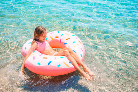 Adorable girl on inflatable air mattress in the sea