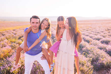 Family in lavender flowers field at dawn